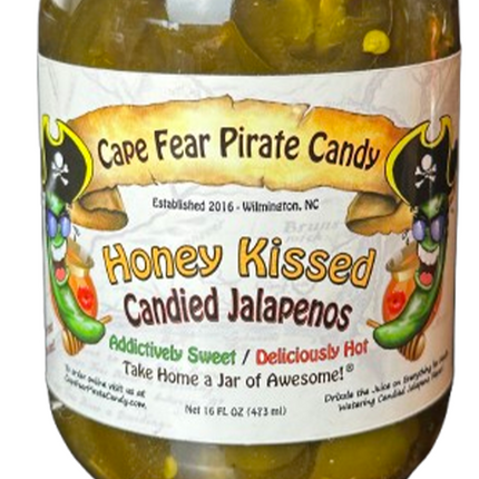A jar of Cape Fear Pirate Candy 'Honey Kissed Candied Jalapeños' with a white label featuring pirate illustrations and yellow text, filled with honey-colored jalapeños.