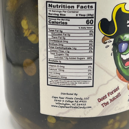 Close-up of a jar label showing nutrition facts, with part of a green cartoon character and the text 'Don't Forget The Sauce!' visible. The jar contents appear dark brown through the clear plastic.